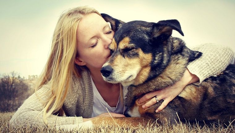אישה מחבקת ומנשקת ברוך כלב כלב